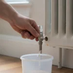 Clé de purge insérée dans le purgeur d'un radiateur